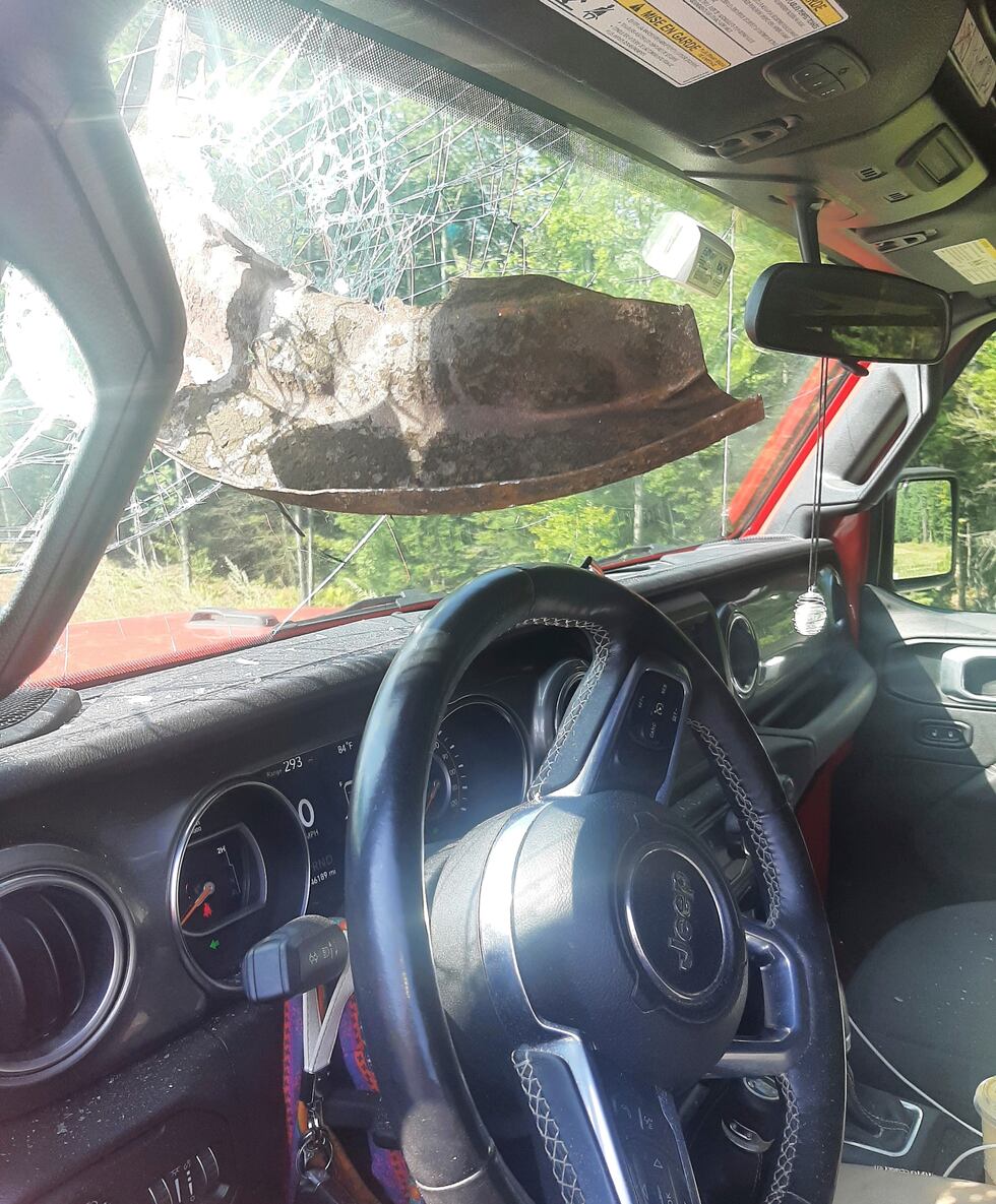 This photo provided by the Maine State Police shows a Jeep that was struck by a piece of metal...